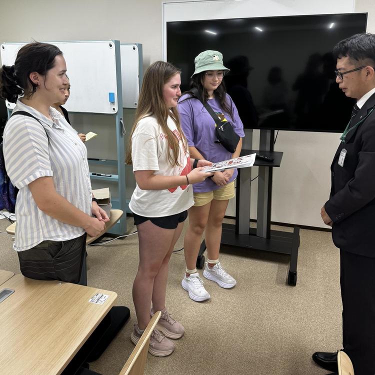 The NP team handing Rebun Kayo (right) a letter and Princeton swag. 